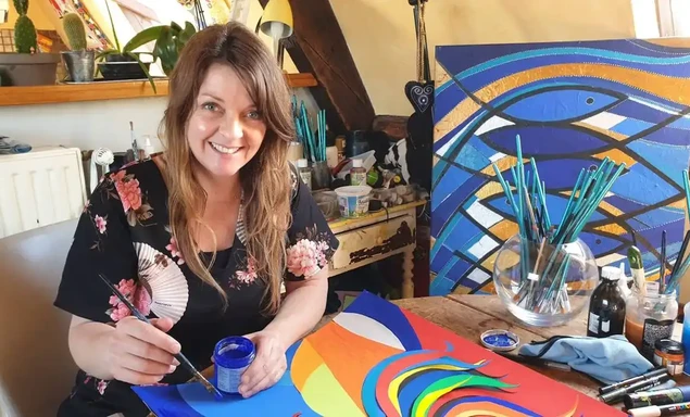 portrait d'Amélie Fish, souriante, travaillant dans son atelier