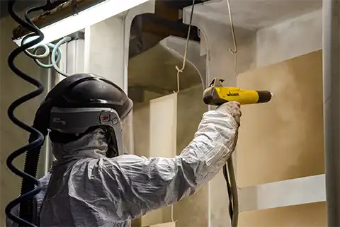 Personne qui thermolaque des morceaux d'un portail