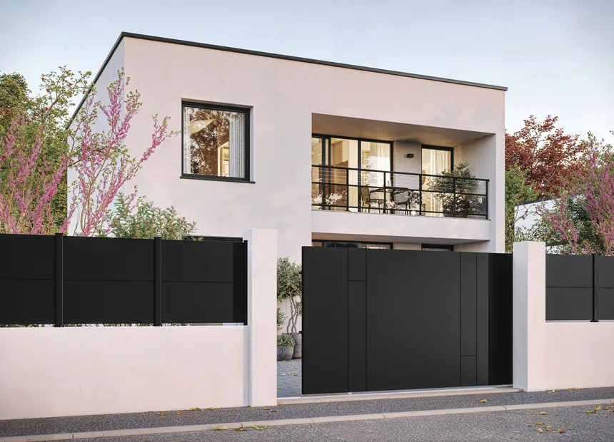 Puerta corredera y barandilla de aluminio Kostum ante una casa contemporánea