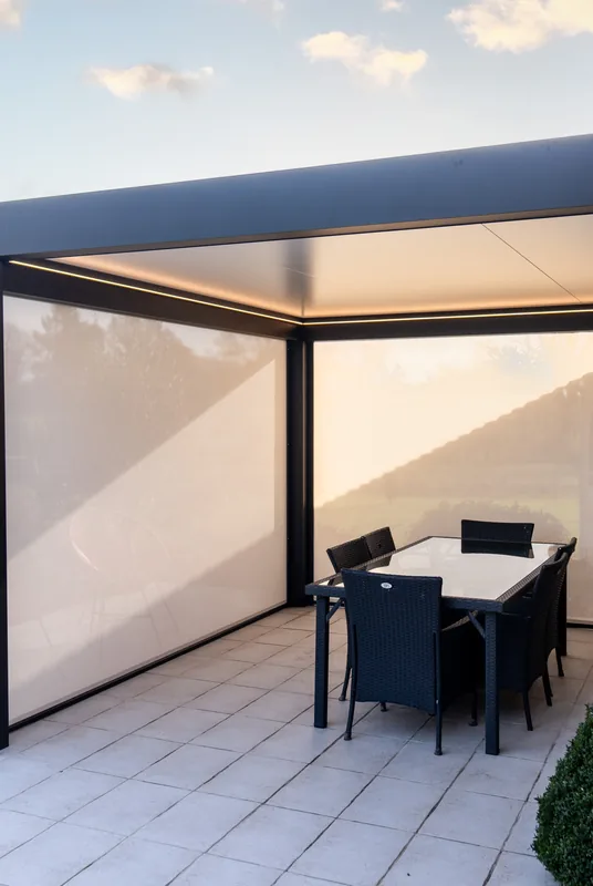Pérgola adosada de aluminio Lily Kostum equipada con cortinas zip blancas
