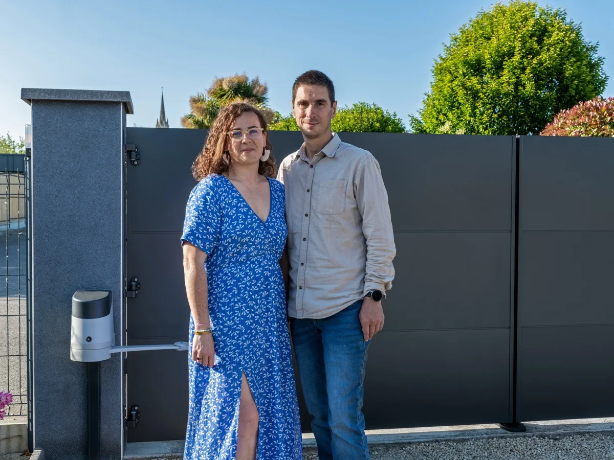 Una pareja delante de su puerta Kostum durante un reportaje fotográfico